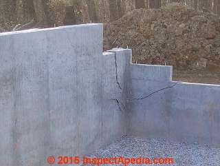 Severe diagnoal cracks at the corner of a newly-poured concrete foundation (C) InspectApedia.com